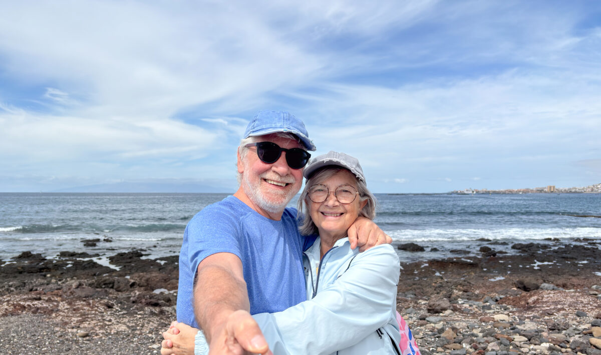Happy senior couple at the beach taking selfie