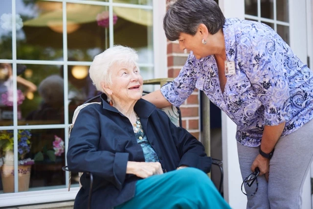 Caregiver and senior woman speaking outdoors