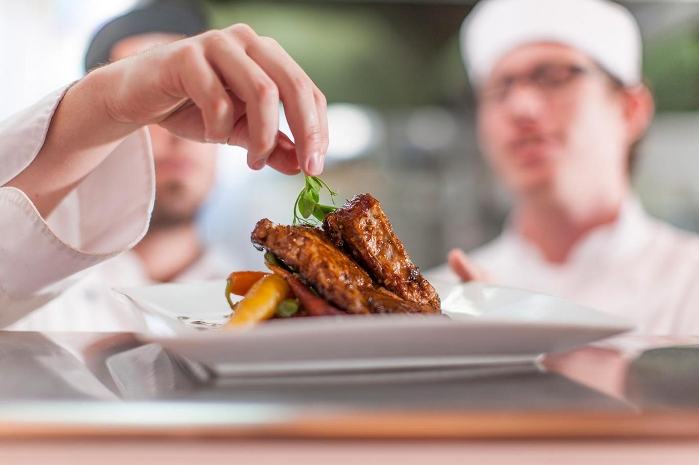 Chefs preparing meat dish