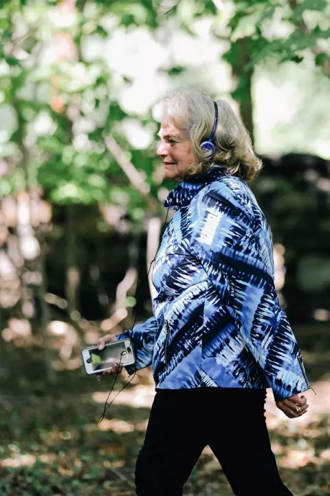 Senior woman walking with headphones on