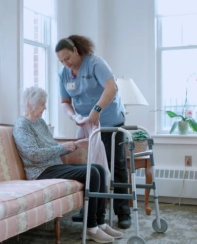 Staff helping rehab patient put on sweater