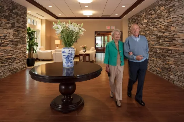 Senior man and woman walking through independent living community