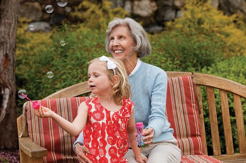 Grandmother and granddaughter blowing bubbles