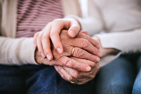 Woman and senior holding hands
