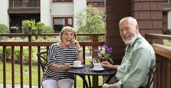 Senior man and woman having tea outdoors