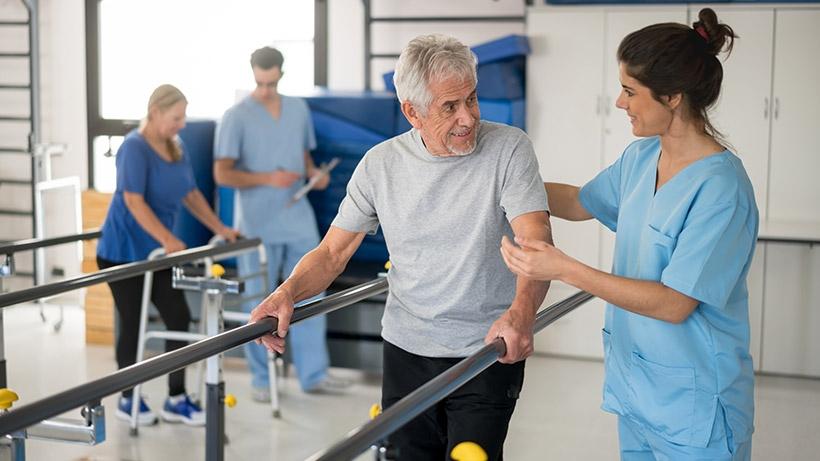 Older man doing injury rehab with nurse