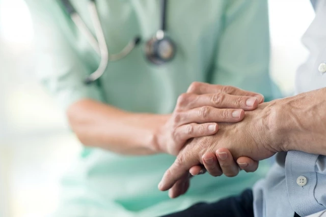 Caregiver and resident holding hands