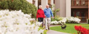 Senior man and senior woman walking dog