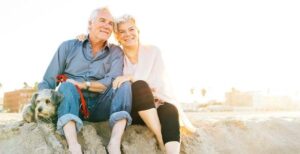 Senior couple with dog on beach