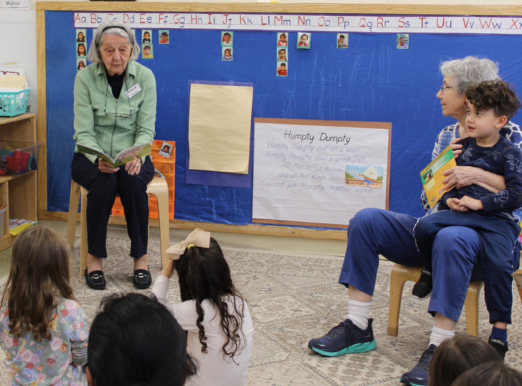 Resident Grace B. and Gail S. reading tp children