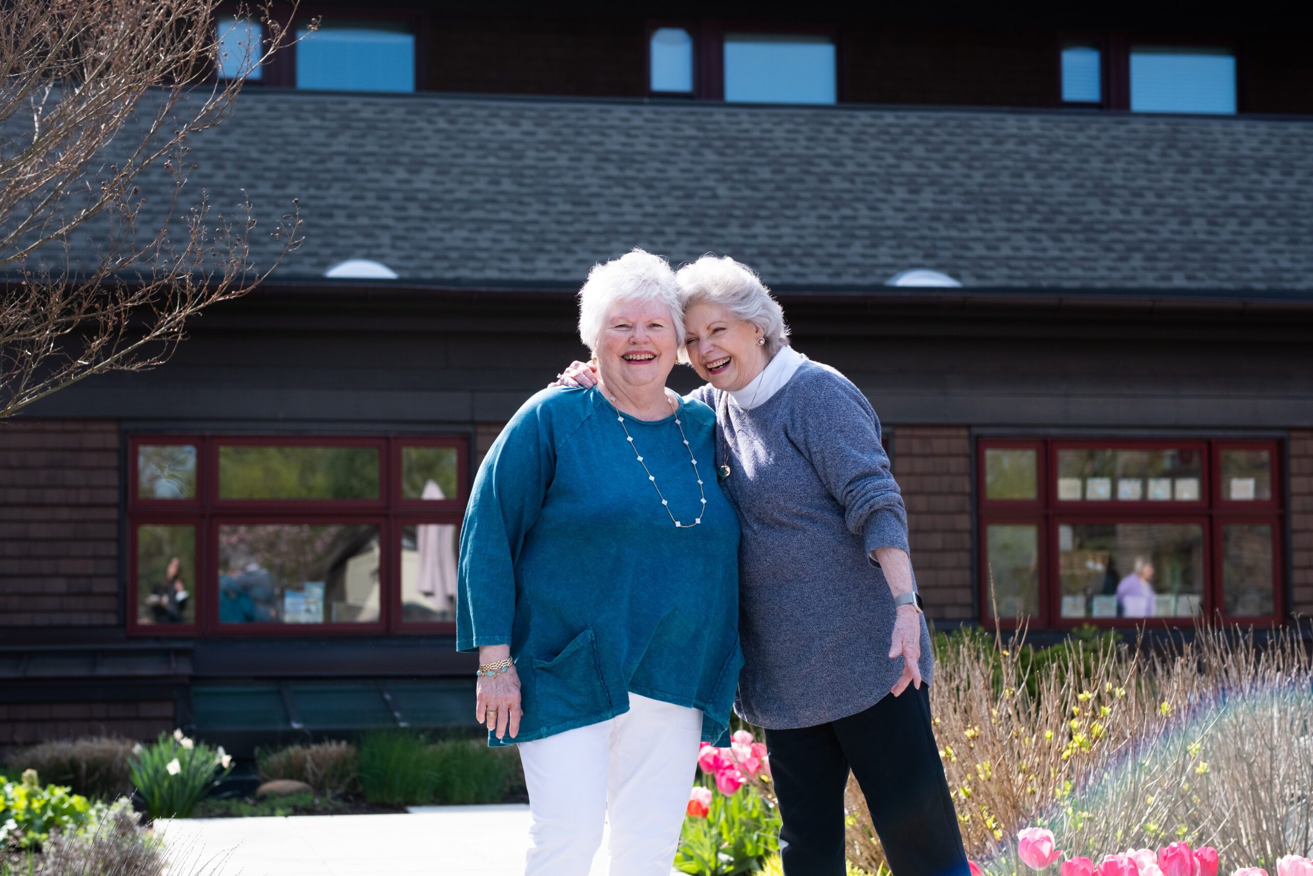 Two older women embrace on the Edgehill bocci court