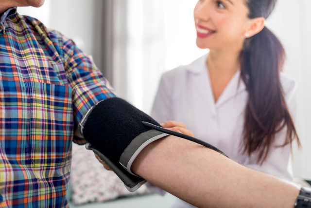 nurse taking older adult resident's blood pressure